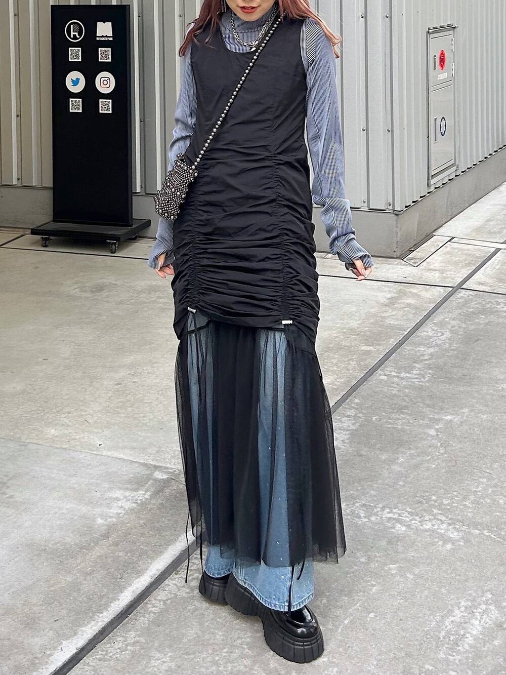 ブラック系のワンピース、ブルー系のTシャツ/カットソー、ブラック系のショルダーバッグを着用したレディースの春コーディネートの3枚目の写真