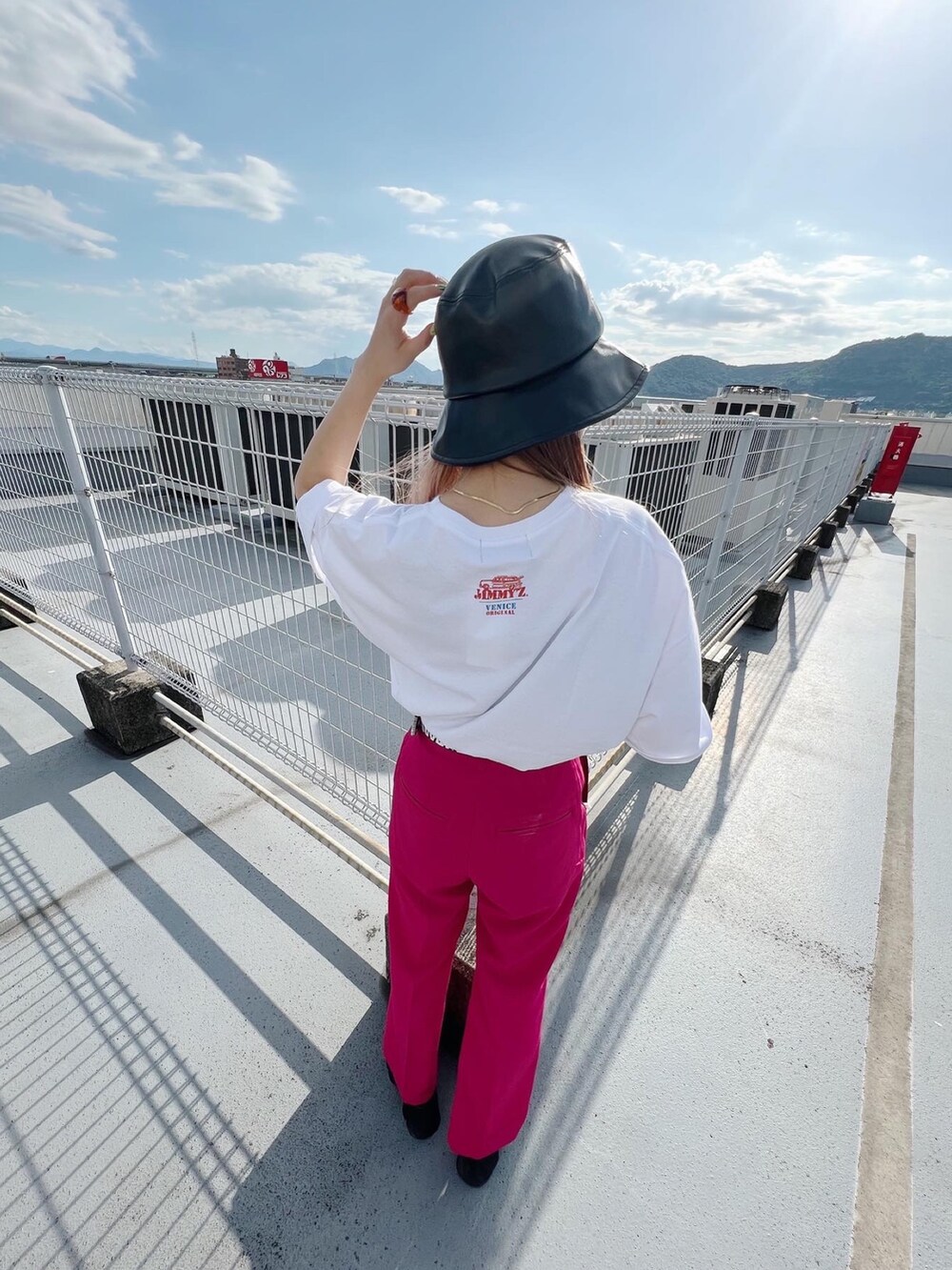 ブラック系のサンダル、ピンク系のスラックス、ブラック系のショルダーバッグを着用したレディースの夏コーディネートの3枚目の写真