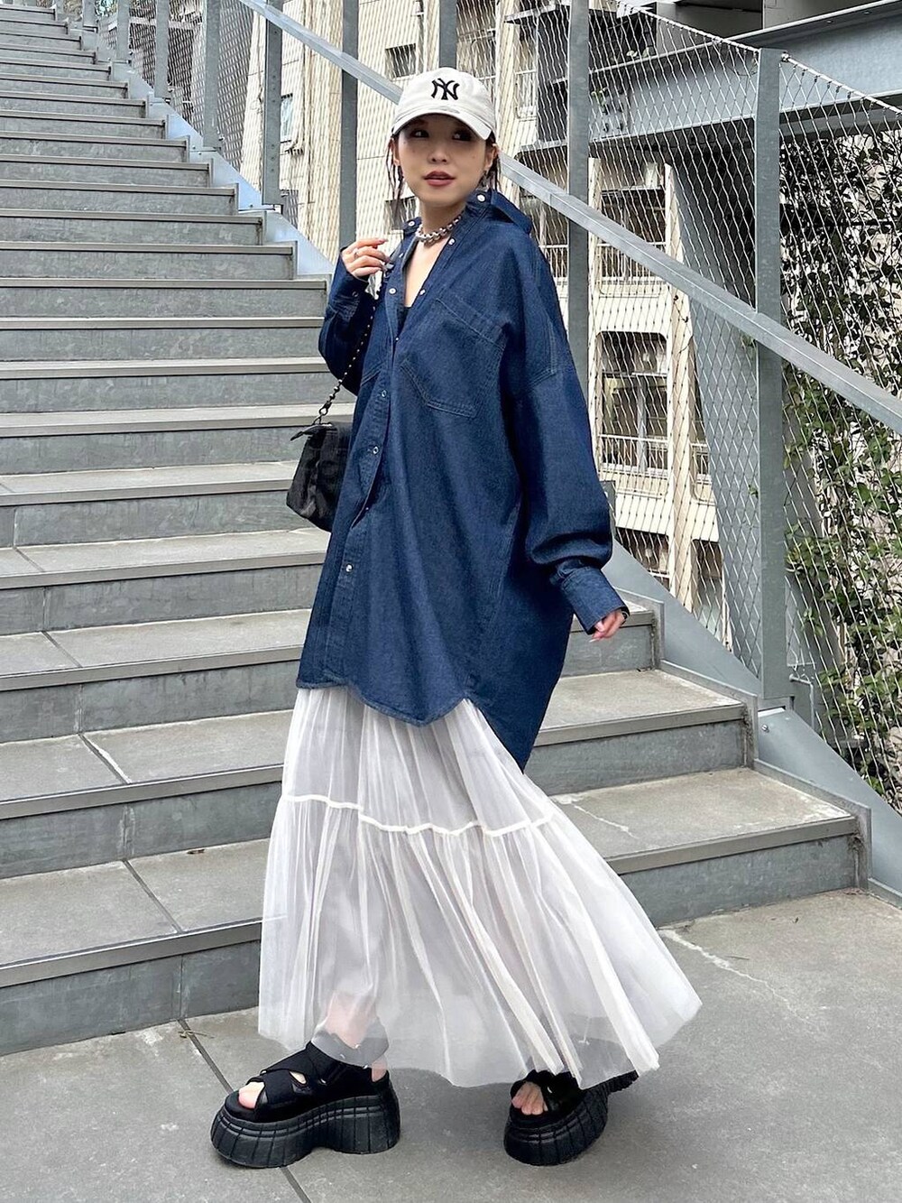 ブラック系のスニーカー、ブラック系のショルダーバッグ、ブラック系のキャミソールを着用したレディースの夏コーディネートの2枚目の写真