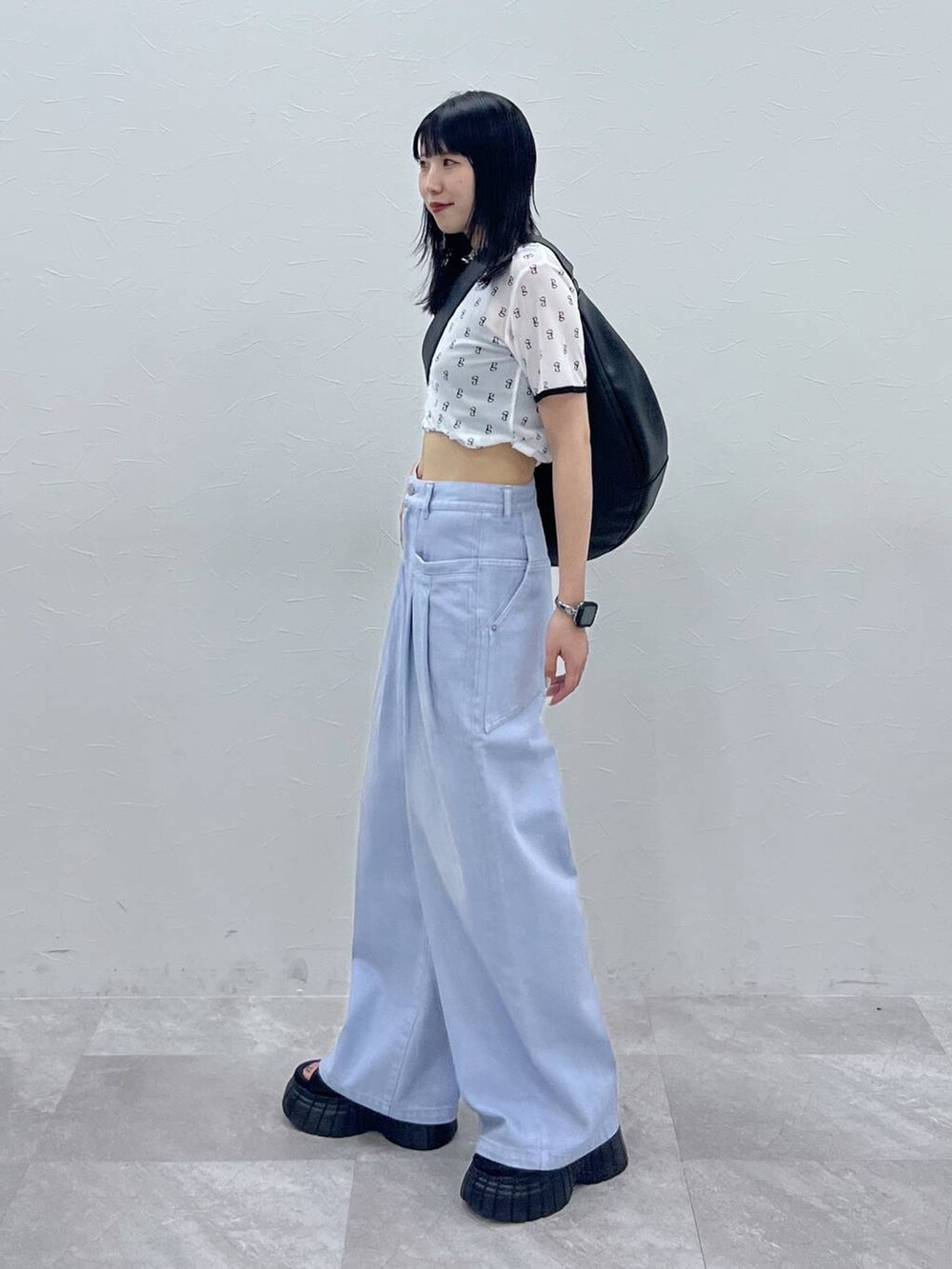 ブラック系のスニーカー、ブルー系のデニムパンツ、ホワイト系のTシャツ/カットソーを着用したレディースの夏コーディネートの3枚目の写真