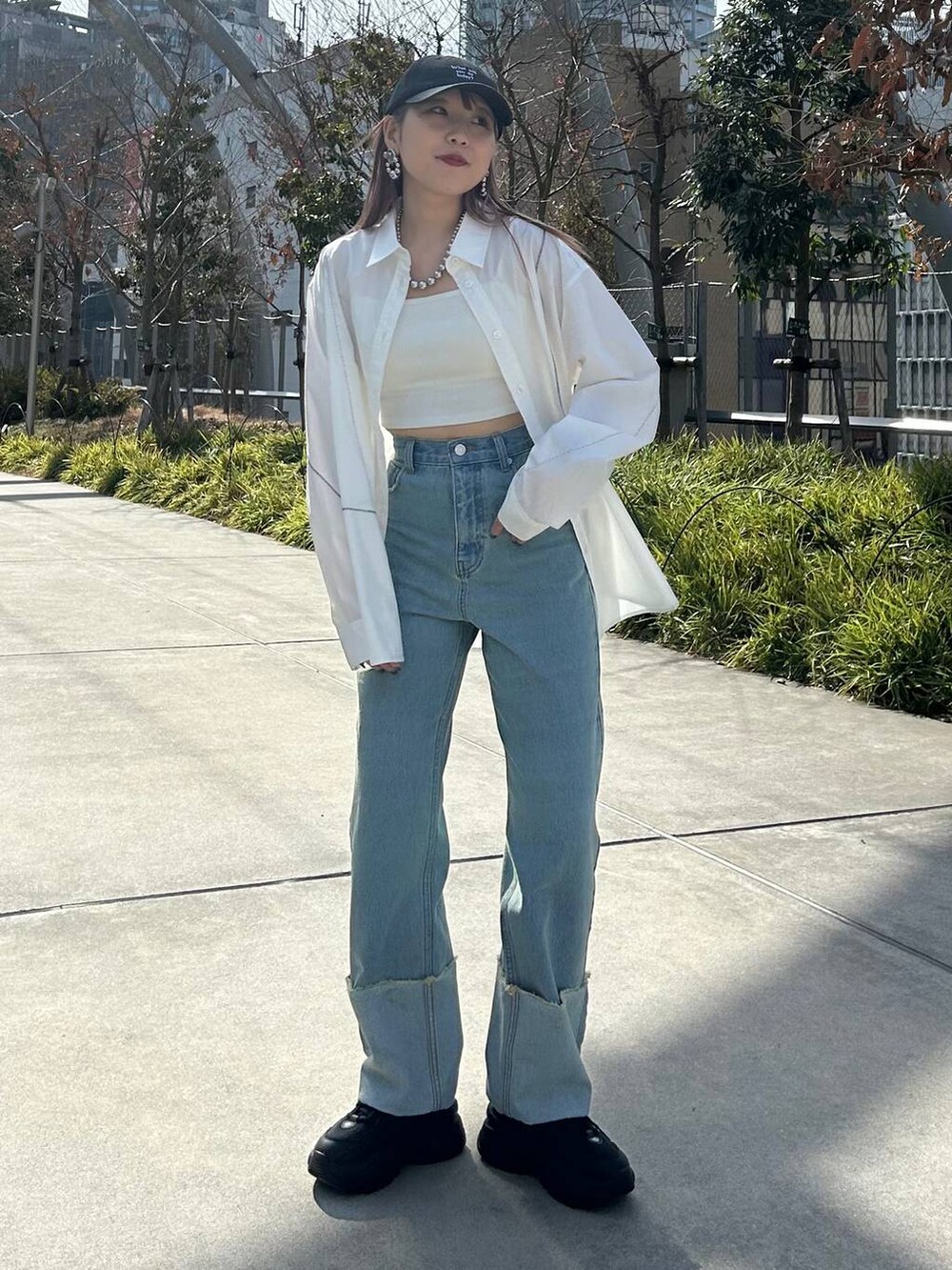 ホワイト系のシャツ/ブラウス、ホワイト系のキャミソール、ブラック系のスニーカーを着用したレディースの春コーディネートの2枚目の写真