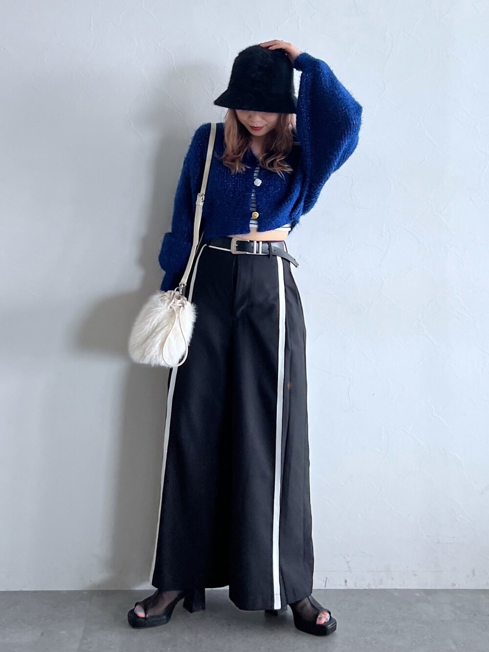 グリーン系のキャミソール、ブラック系のショルダーバッグ、ブルー系のカーディガン/ボレロを着用したレディースの夏コーディネートの2枚目の写真