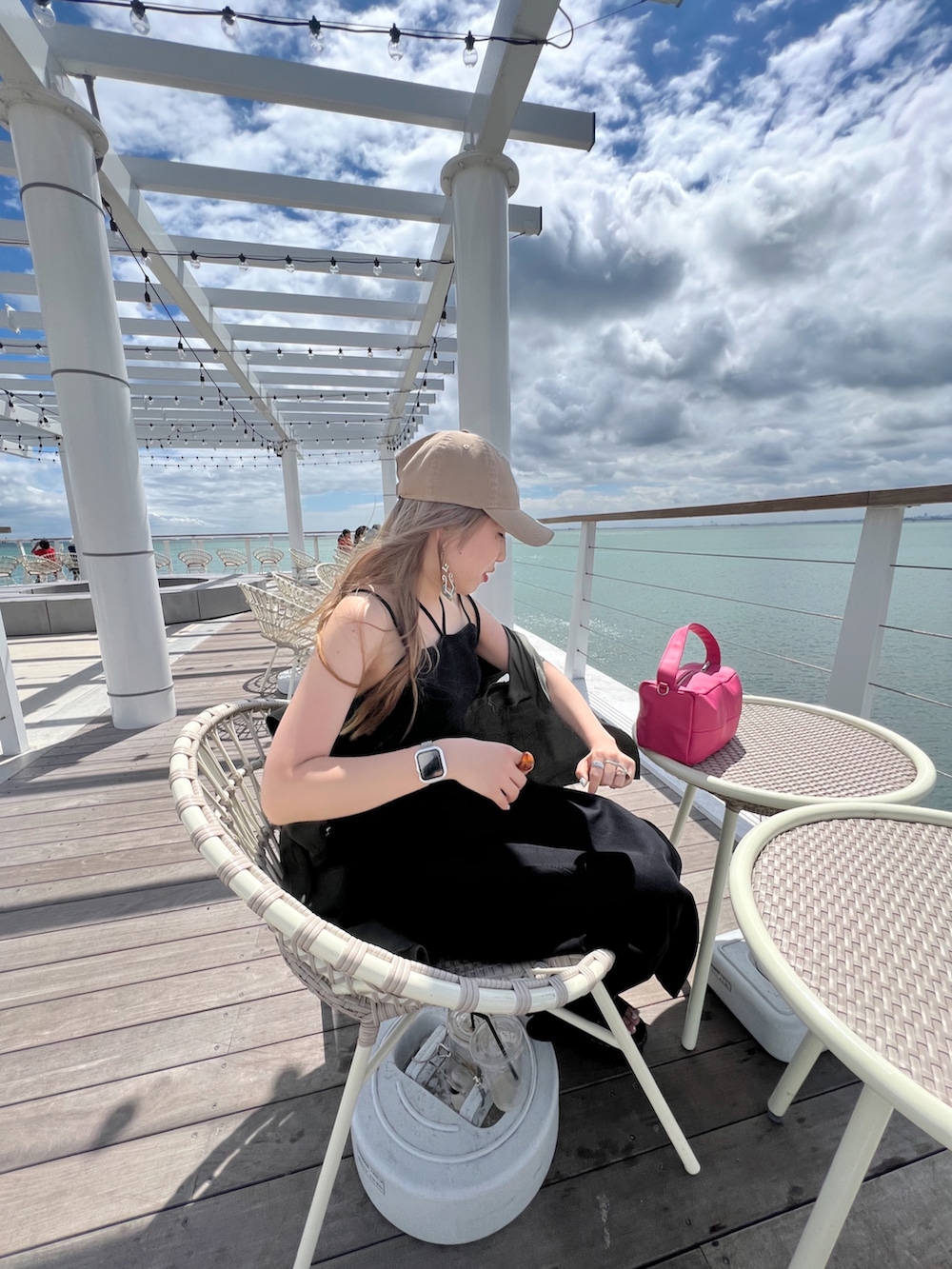 ブラック系のバッグ、ブラック系のワンピース、シルバー系のリングを着用したレディースの夏コーディネートの3枚目の写真