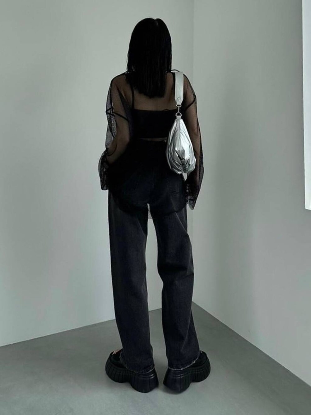 ブラック系のスニーカー、ブラック系のキャミソール、ブラック系のデニムパンツを着用したレディースの春コーディネートの2枚目の写真