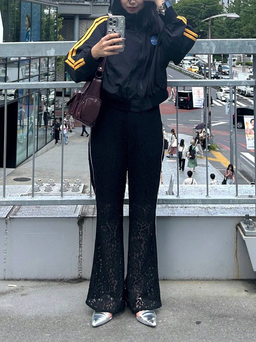 レッド系のショルダーバッグ、ブラック系のその他パンツを着用したレディースの秋コーディネートの2枚目の写真