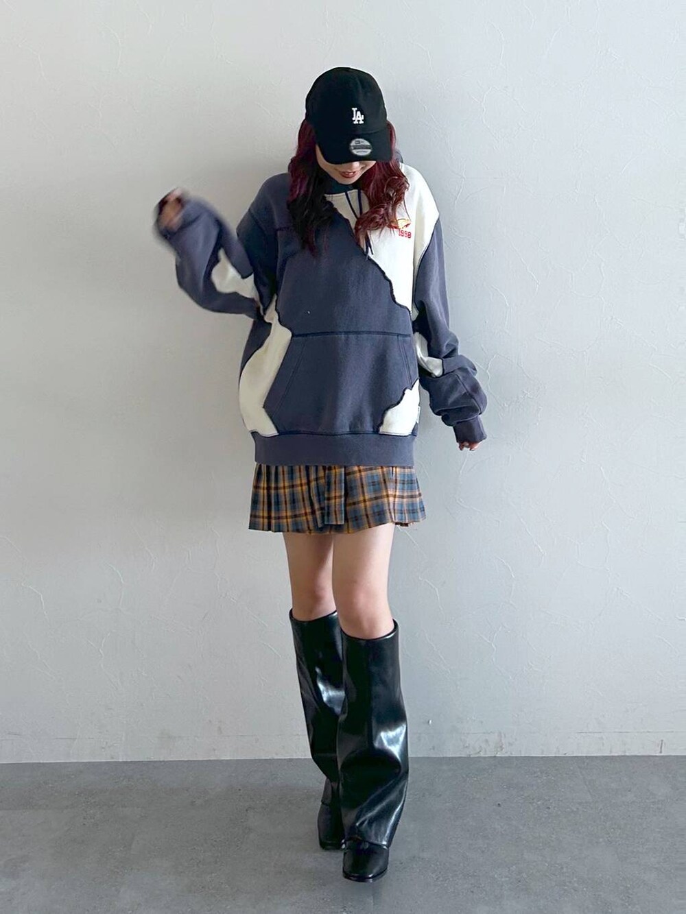 ブラック系のブーツ、ブルー系のパーカー、レッド系のスカートを着用したレディースの秋コーディネートの2枚目の写真