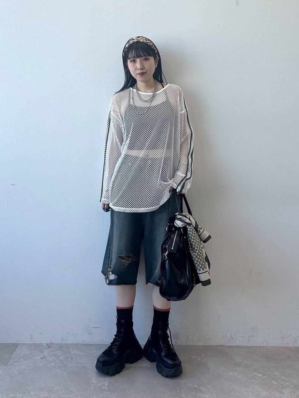 ブラック系のブーツ、ブラック系のトートバッグ、ホワイト系のTシャツ/カットソーを着用したレディースの春コーディネートの2枚目の写真