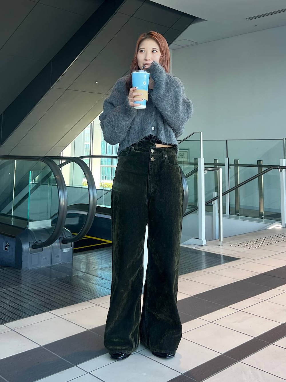 グリーン系のデニムパンツを着用したレディースの冬コーディネートの2枚目の写真