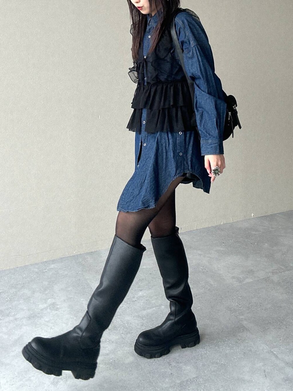 ブラック系のショルダーバッグ、ブルー系のシャツ/ブラウス、ブラック系のブーツを着用したレディースの春コーディネートの3枚目の写真