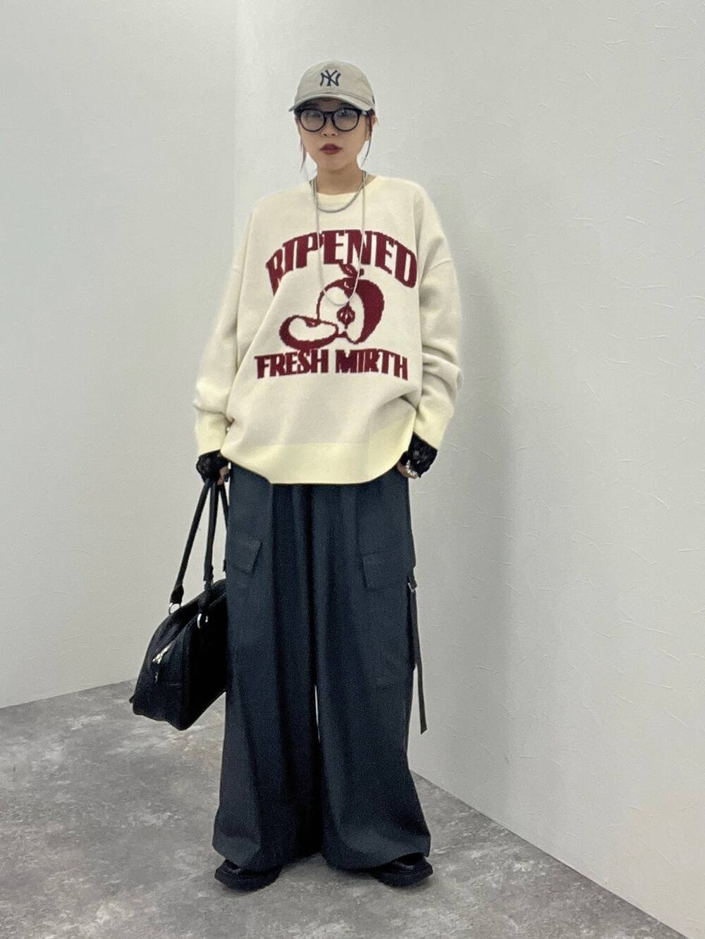 ブラック系のTシャツ/カットソー、グレー系のスラックス、ブラック系のボストンバッグを着用したレディースの秋コーディネートの2枚目の写真