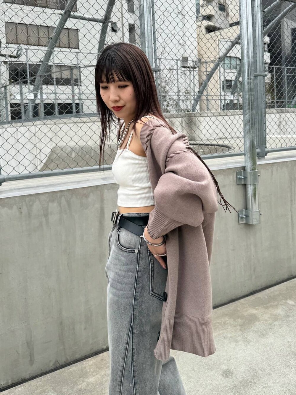 ホワイト系のキャミソール、ブラウン系のカーディガン/ボレロ、ブラック系のデニムパンツを着用したレディースの春コーディネートの2枚目の写真