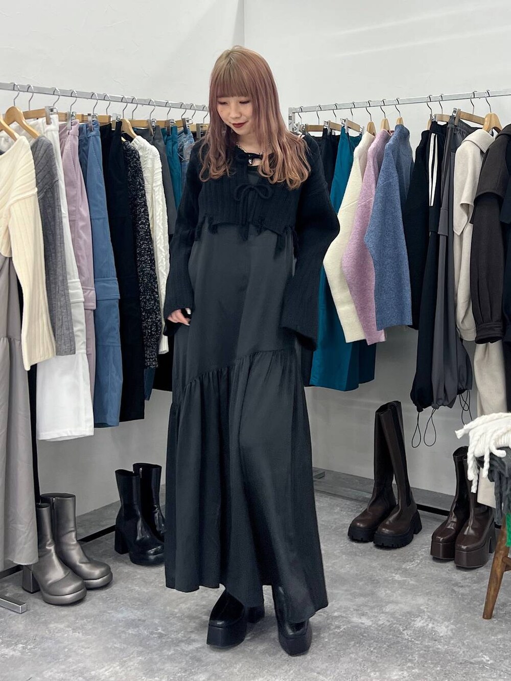 ブラック系のブーツ、ブラック系のワンピース、シルバー系のネックレスを着用したレディースの冬コーディネートの2枚目の写真