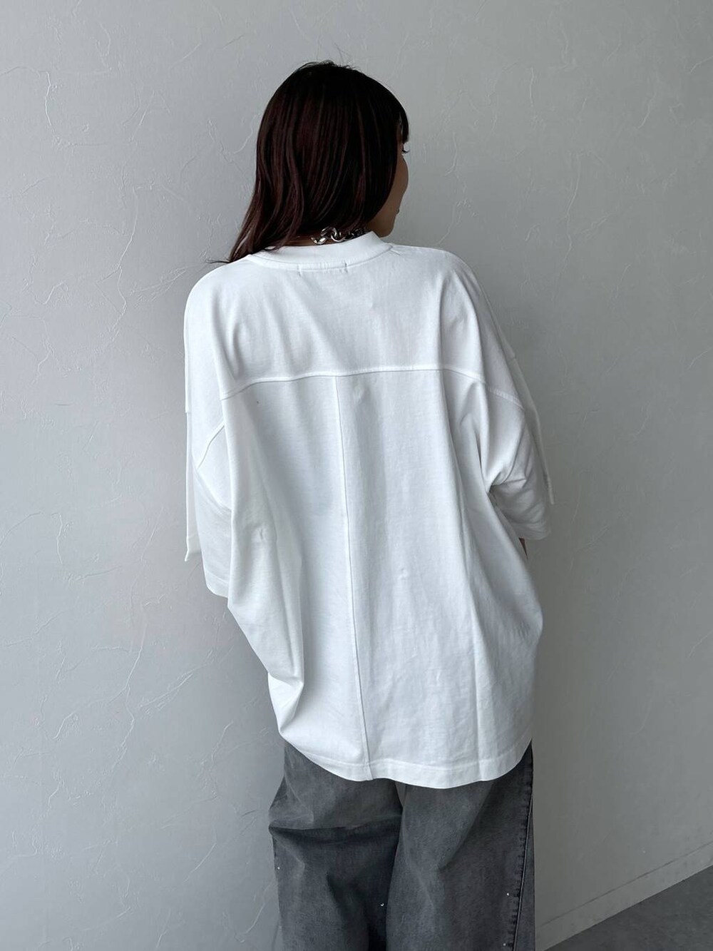 ホワイト系のTシャツ/カットソー、ブラック系のデニムパンツ、シルバー系のネックレスを着用したレディースの夏コーディネートの3枚目の写真