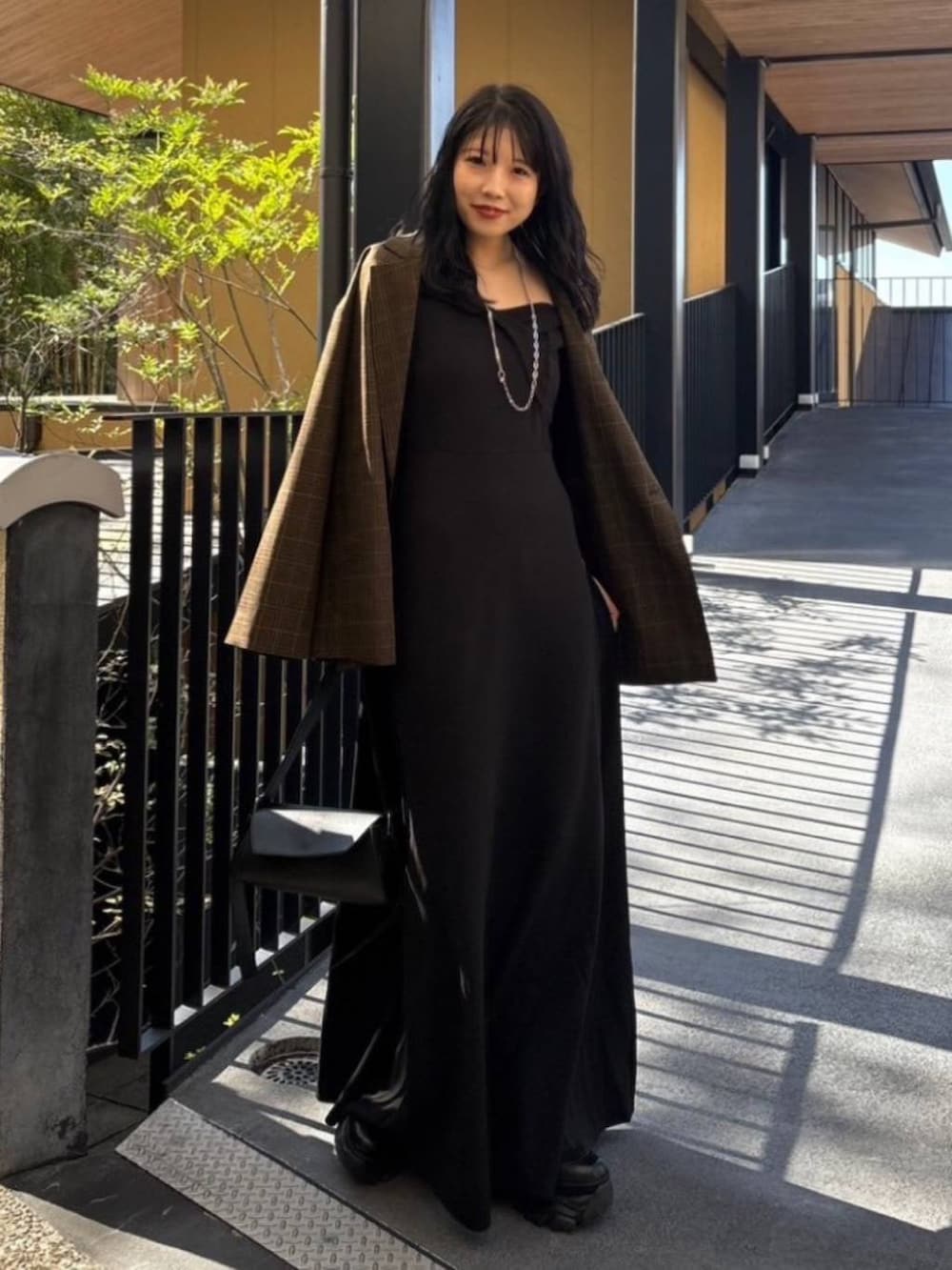 その他のテーラードジャケット、ブラック系のブーツ、シルバー系のネックレスを着用したレディースの秋コーディネートの2枚目の写真