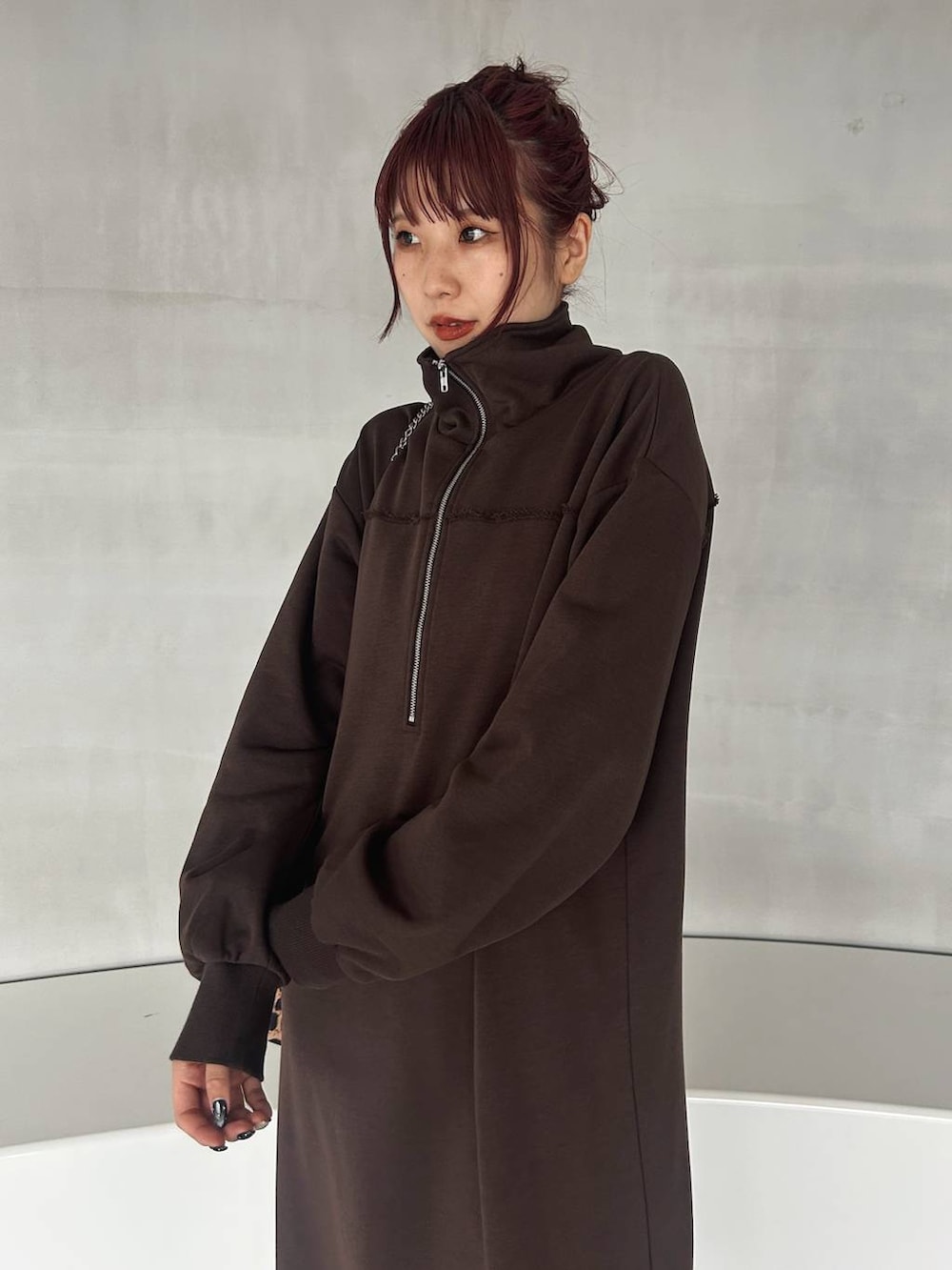 その他のハンドバッグ、ブラック系のブーツ、ブラウン系のワンピースを着用したレディースの秋コーディネートの5枚目の写真