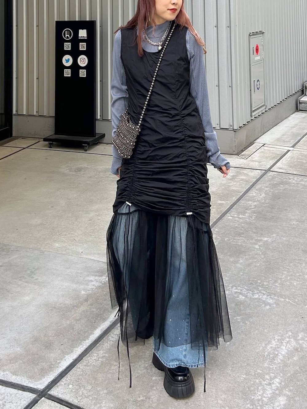 ブラック系のワンピース、ブルー系のTシャツ/カットソー、ブラック系のショルダーバッグを着用したレディースの春コーディネートの2枚目の写真