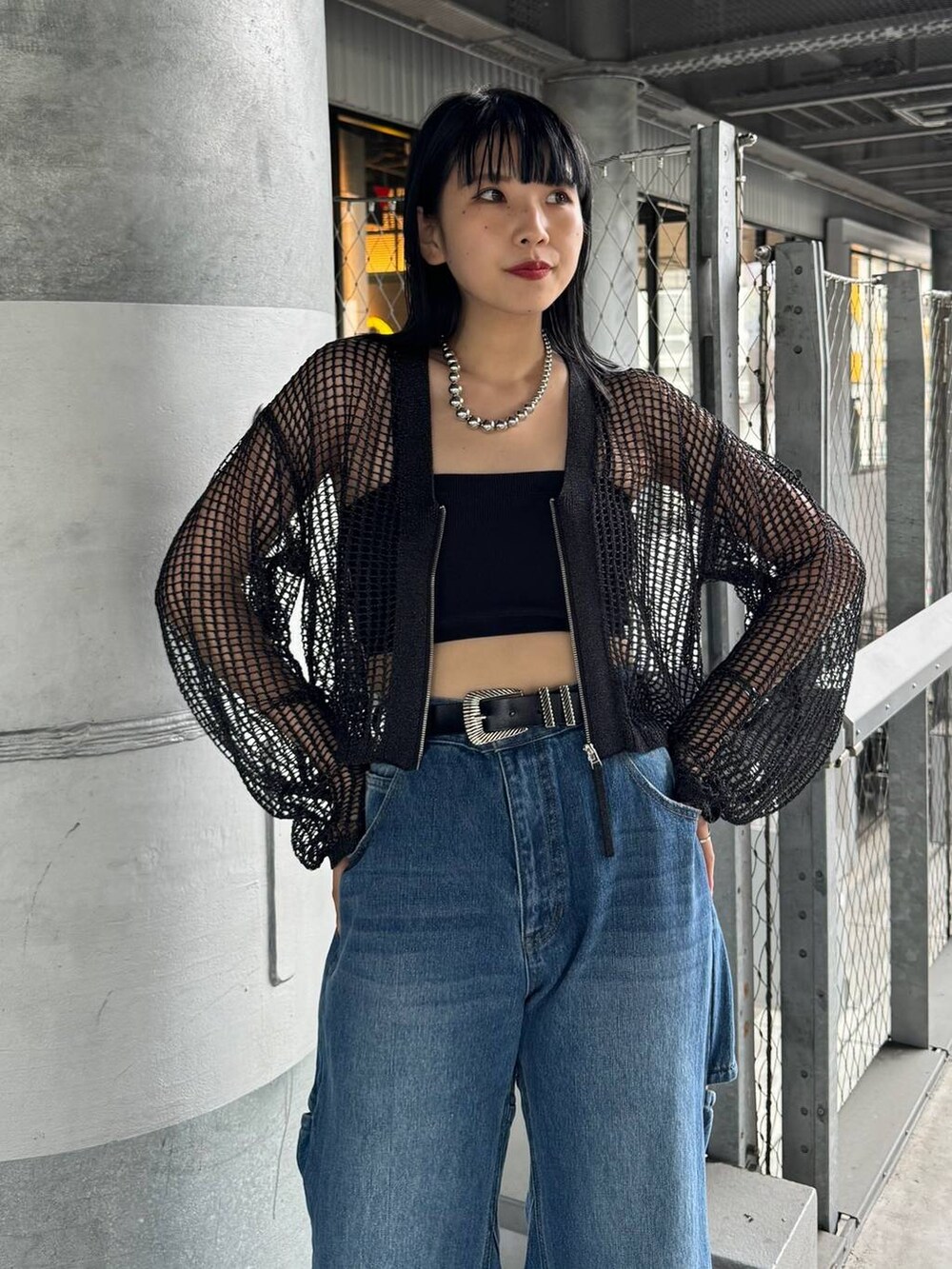 ブラック系のカーディガン/ボレロ、ブルー系のデニムパンツ、シルバー系のネックレスを着用したレディースの春コーディネートの2枚目の写真