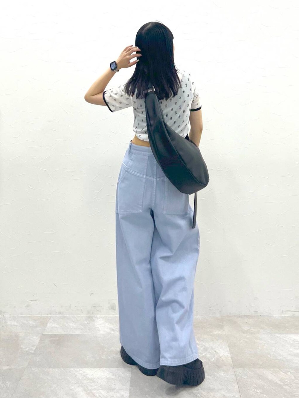 ブラック系のスニーカー、ブルー系のデニムパンツ、ホワイト系のTシャツ/カットソーを着用したレディースの夏コーディネートの4枚目の写真