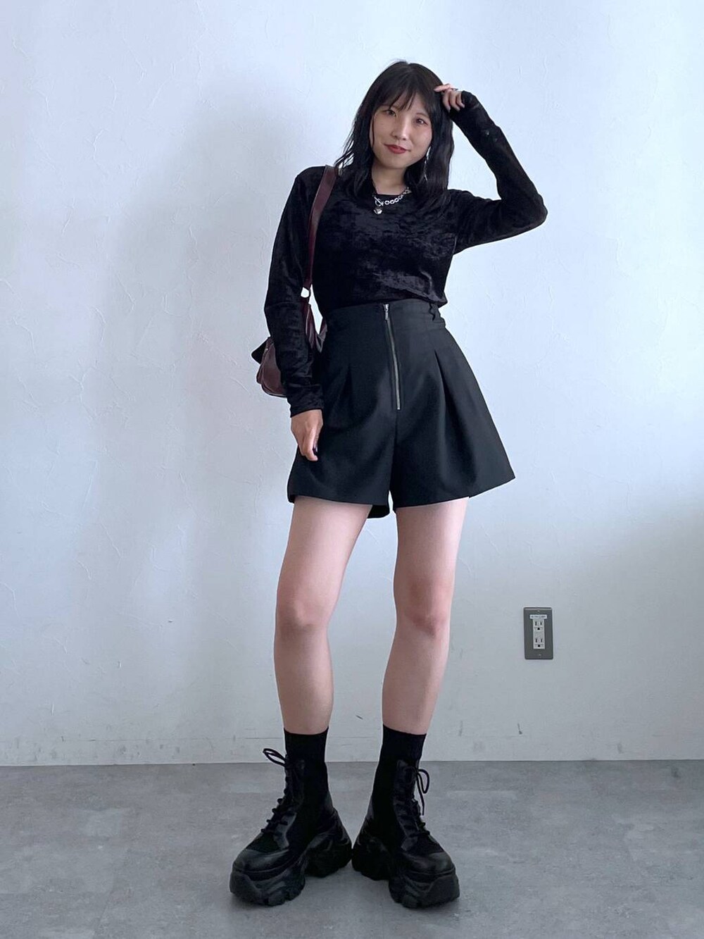 ブラック系のブーツ、レッド系のショルダーバッグ、ブラック系のその他パンツを着用したレディースの秋コーディネートの4枚目の写真