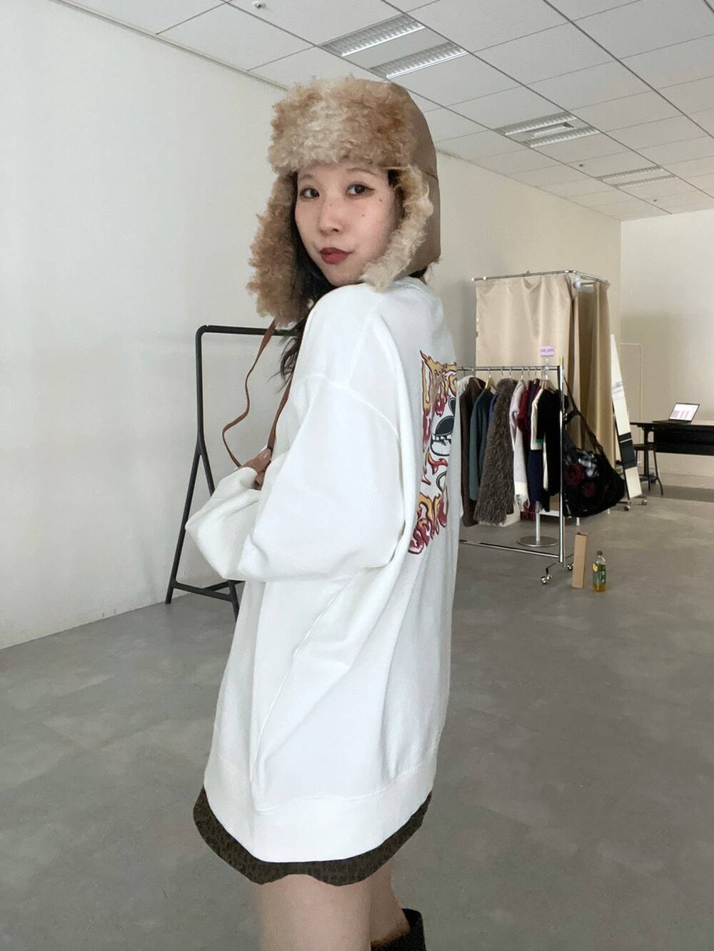 その他のスカート、ホワイト系のスウェット、ブラウン系のキャップを着用したレディースの冬コーディネートの2枚目の写真