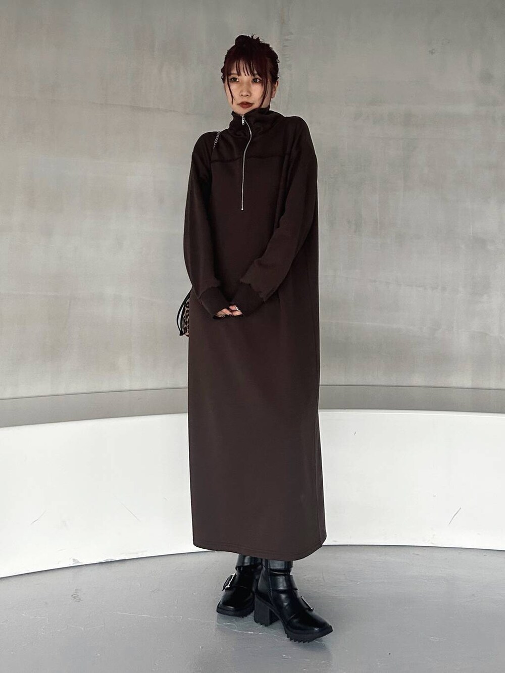 その他のハンドバッグ、ブラック系のブーツ、ブラウン系のワンピースを着用したレディースの秋コーディネートの3枚目の写真