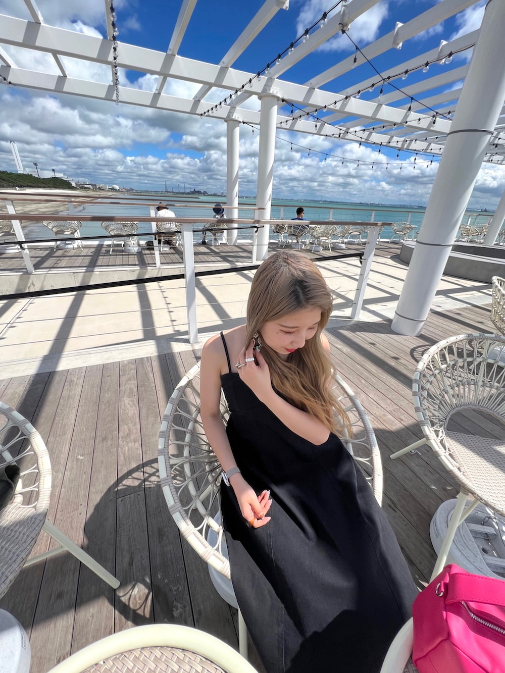 ブラック系のバッグ、ブラック系のワンピース、シルバー系のリングを着用したレディースの夏コーディネートの2枚目の写真