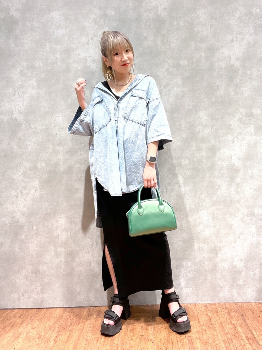 ブルー系のシャツ/ブラウス、ブラック系のスカート、グリーン系のショルダーバッグを着用したレディースの夏コーディネートの2枚目の写真