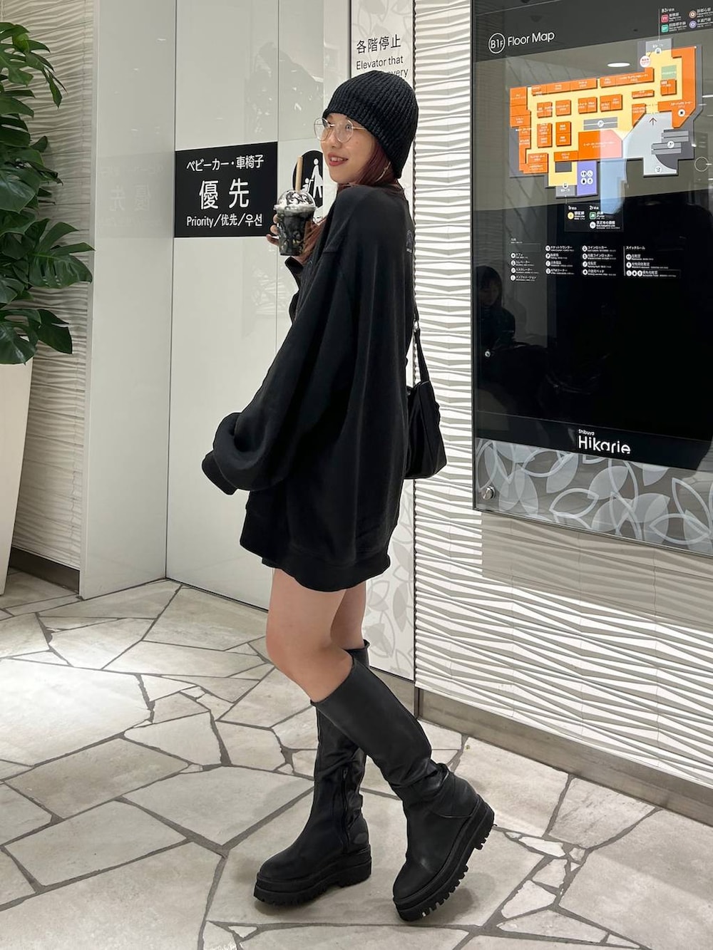 ブラック系のスウェット、ブラック系のブーツを着用したレディースの春コーディネートの2枚目の写真