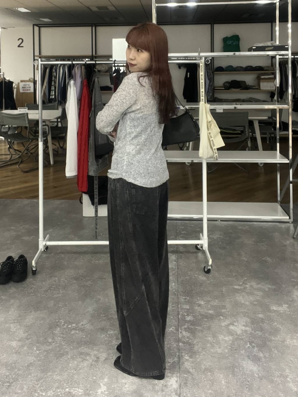 ブラック系のデニムパンツ、ブラック系のハンドバッグ、グレー系のTシャツ/カットソーを着用したレディースの冬コーディネートの2枚目の写真