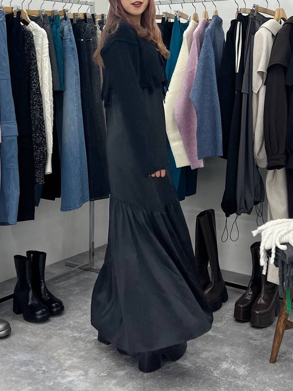 ブラック系のブーツ、ブラック系のワンピース、シルバー系のネックレスを着用したレディースの冬コーディネートの4枚目の写真