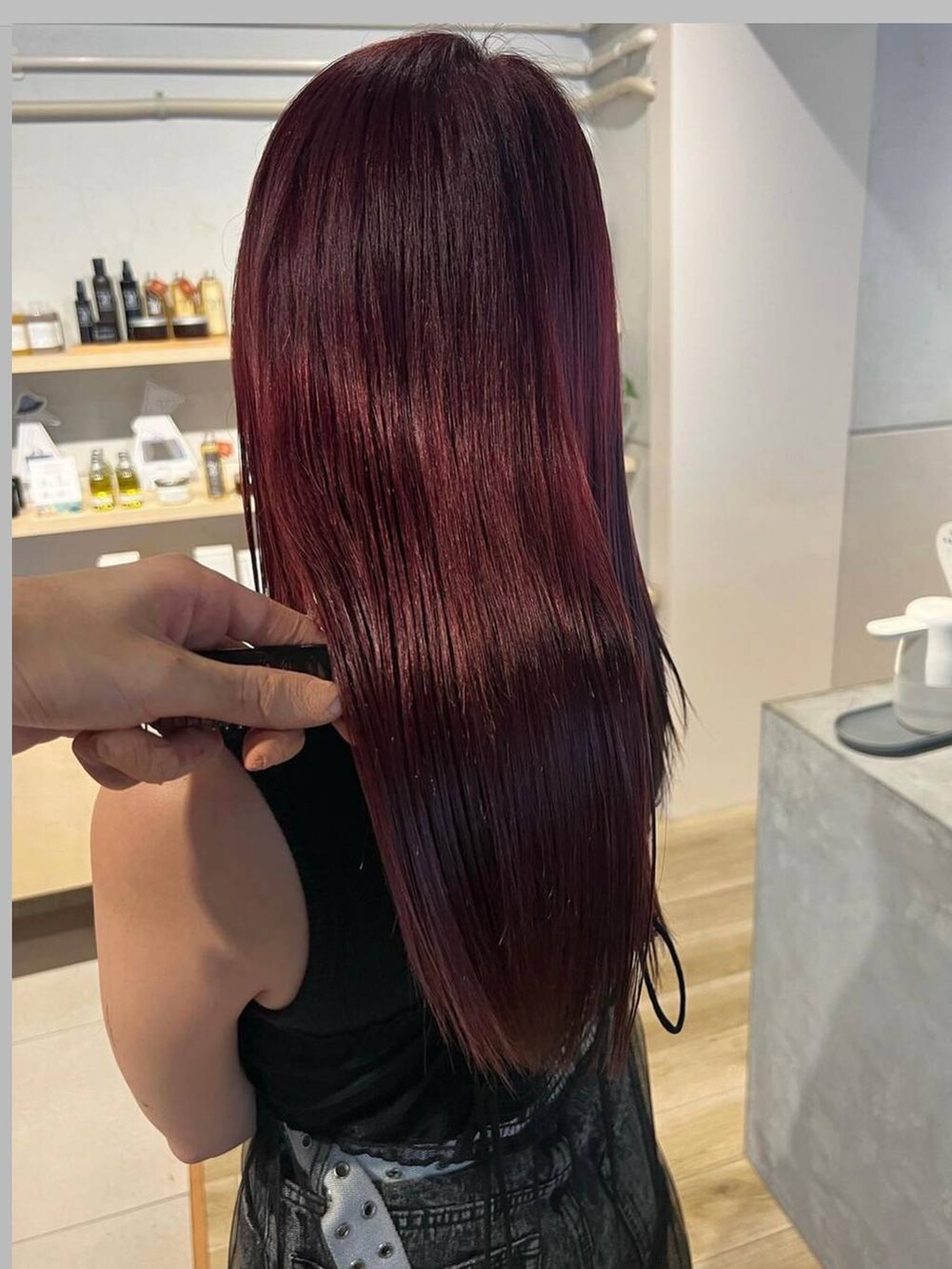 ブラック系のデニムパンツ、ブラック系のタンクトップ、ブラック系のワンピースを着用したレディースの冬コーディネートの4枚目の写真