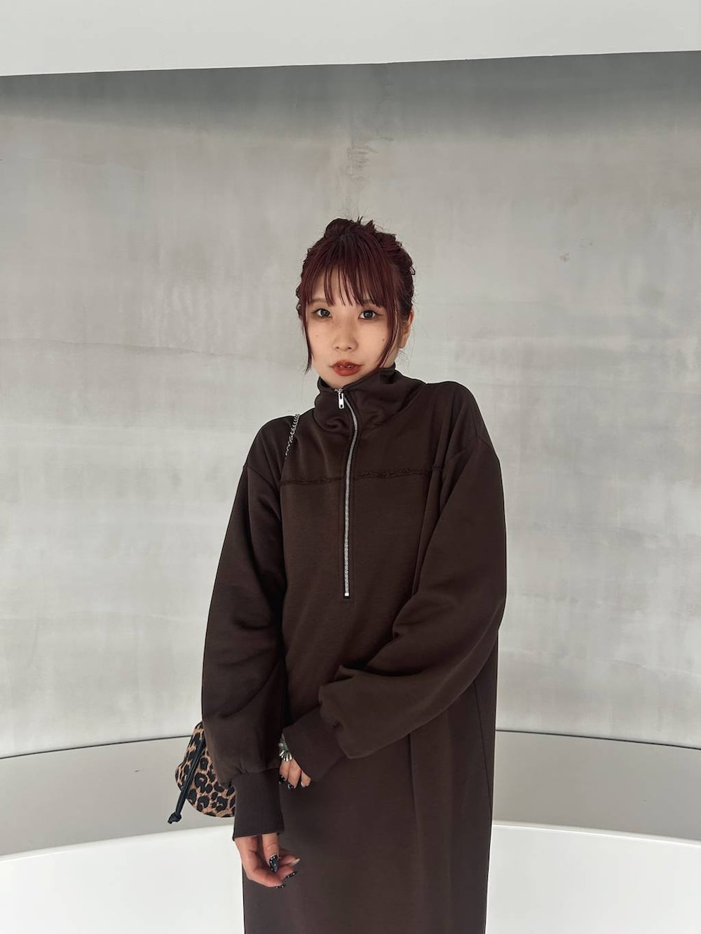 その他のハンドバッグ、ブラック系のブーツ、ブラウン系のワンピースを着用したレディースの秋コーディネートの7枚目の写真