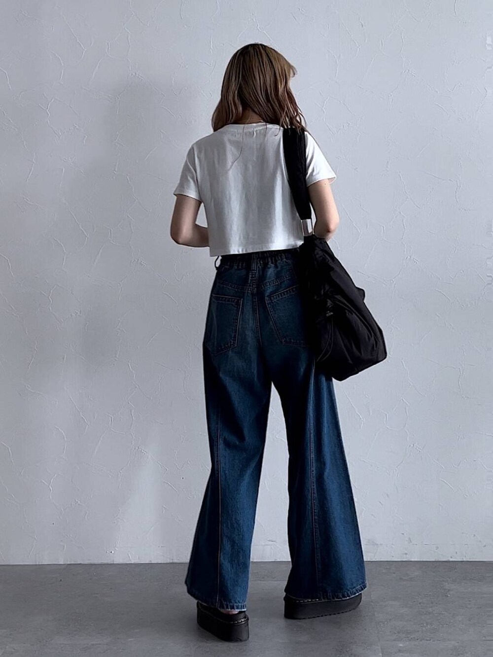 ホワイト系のTシャツ/カットソー、ブルー系のデニムパンツ、ブラック系のショルダーバッグを着用したレディースの夏コーディネートの3枚目の写真