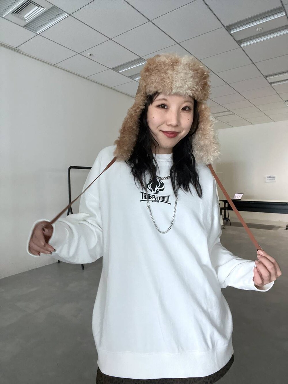 その他のスカート、ホワイト系のスウェット、ブラウン系のキャップを着用したレディースの冬コーディネートの3枚目の写真