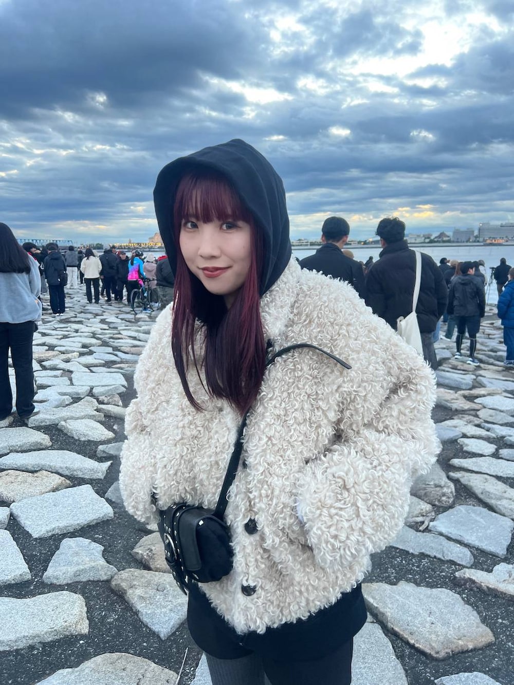 ブラック系のショルダーバッグ、ブラック系のブーツを着用したレディースの冬コーディネートの2枚目の写真