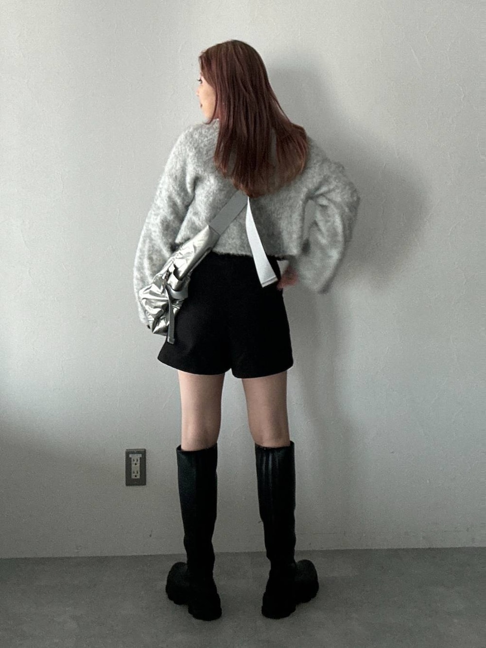 シルバー系のショルダーバッグ、ブラック系のブーツ、ブラック系のその他パンツを着用したレディースの冬コーディネートの3枚目の写真