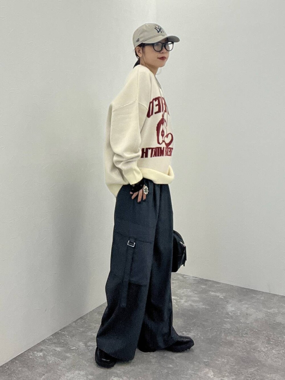 ブラック系のTシャツ/カットソー、グレー系のスラックス、ブラック系のボストンバッグを着用したレディースの秋コーディネートの3枚目の写真