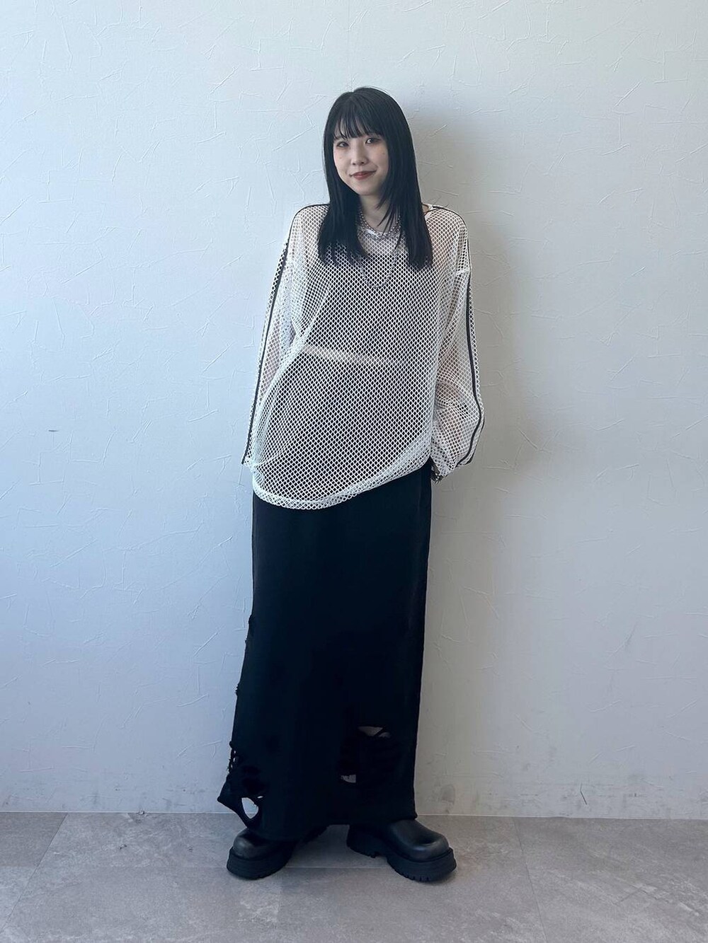 ブラック系のトートバッグ、ブラック系のブーツ、ブラック系のスカートを着用したレディースの春コーディネートの3枚目の写真