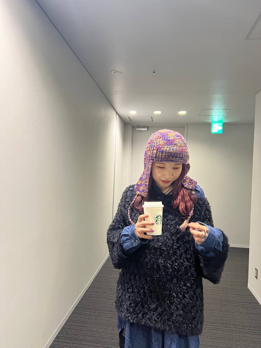 ブルー系のシャツ/ブラウス、ブラック系のブーツ、ブラック系のニット/セーターを着用したレディースの冬コーディネートの4枚目の写真