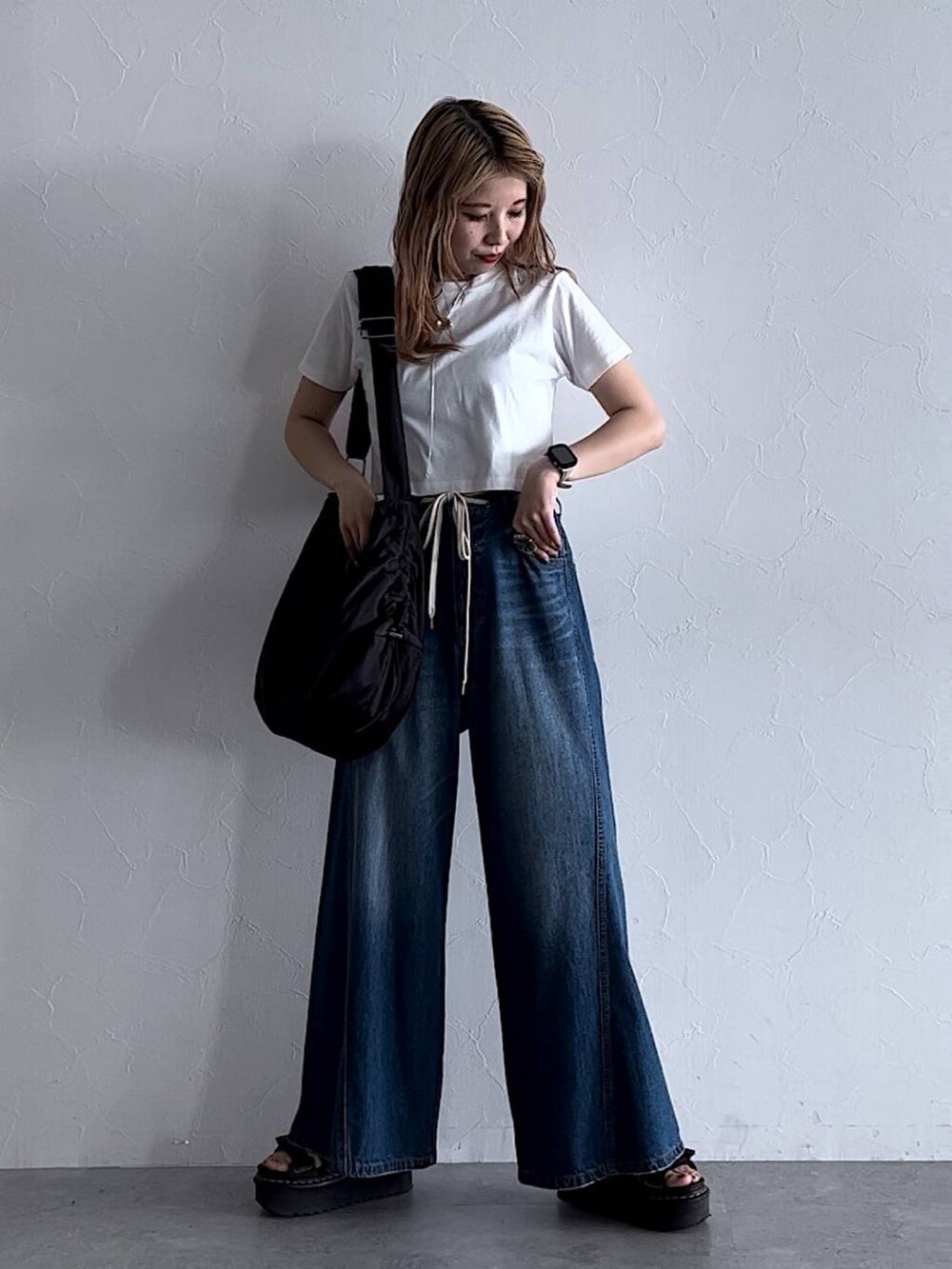 ホワイト系のTシャツ/カットソー、ブルー系のデニムパンツ、ブラック系のショルダーバッグを着用したレディースの夏コーディネートの2枚目の写真