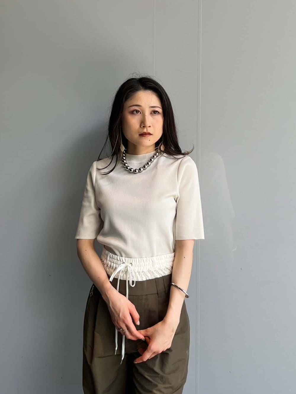 ホワイト系のニット/セーター、グリーン系のその他パンツを着用したレディースの夏コーディネートの4枚目の写真