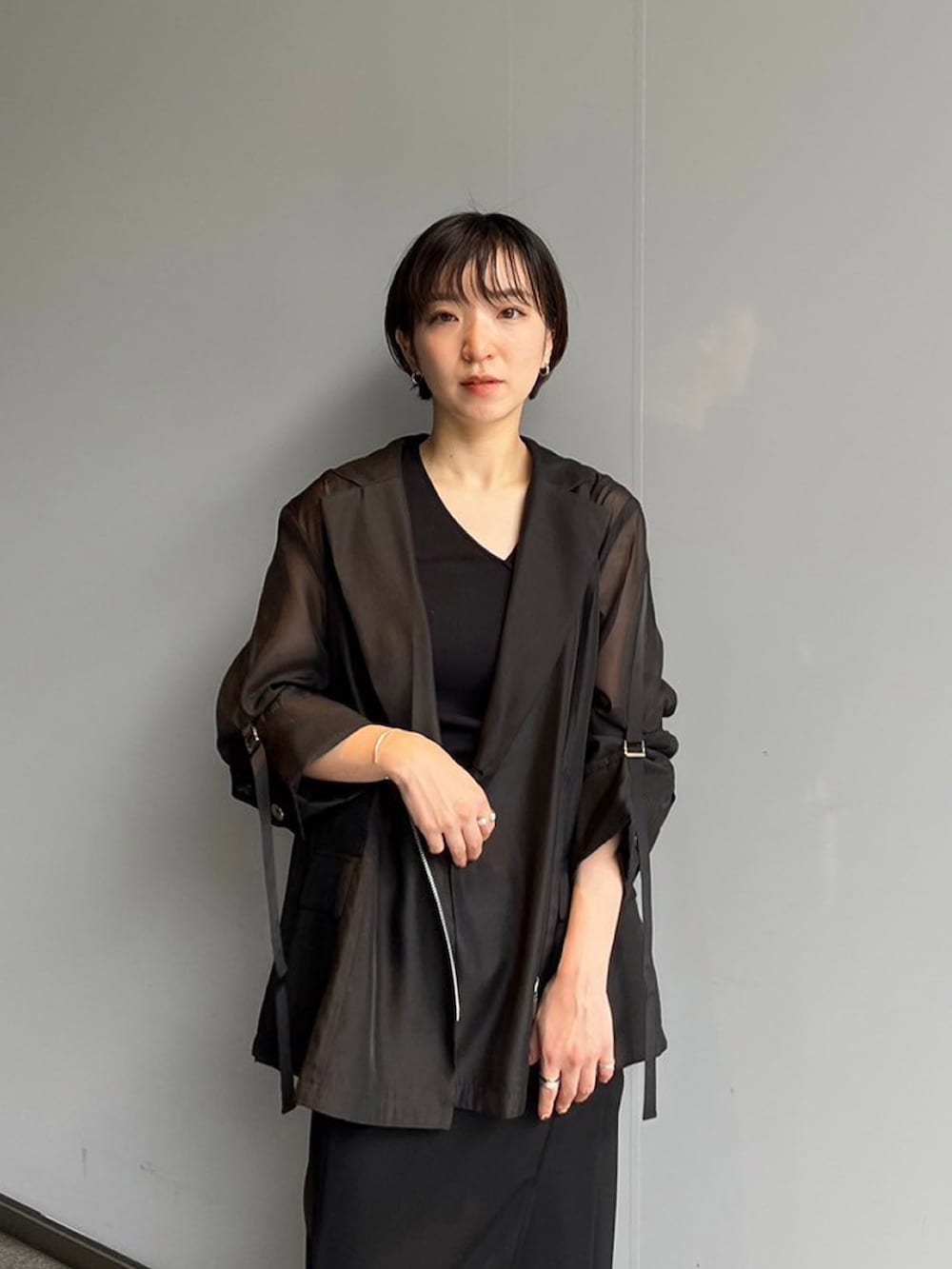 ブラック系のスカート、ブラック系のテーラードジャケットを着用したレディースの夏コーディネートの4枚目の写真