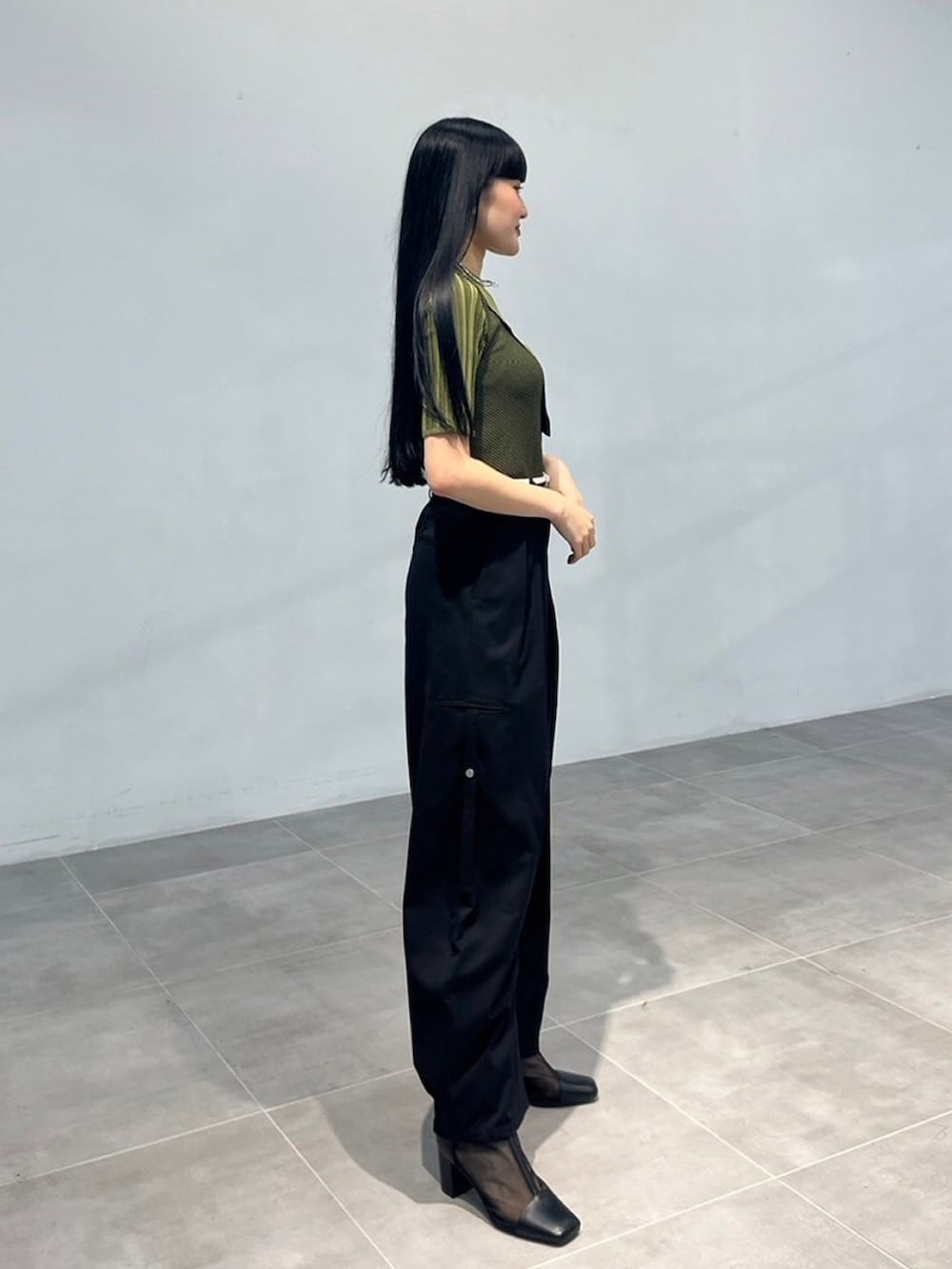 グリーン系のニット/セーター、ブラック系のその他パンツを着用したレディースの秋コーディネートの2枚目の写真