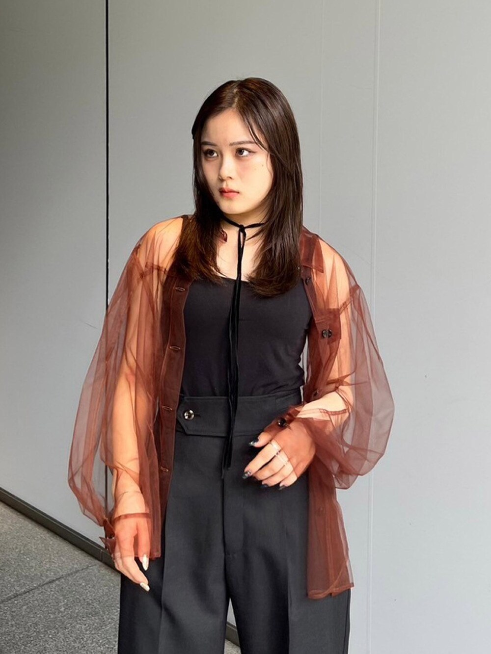 ブラウン系のシャツ/ブラウス、ブラック系のスラックスを着用したレディースの夏コーディネートの3枚目の写真