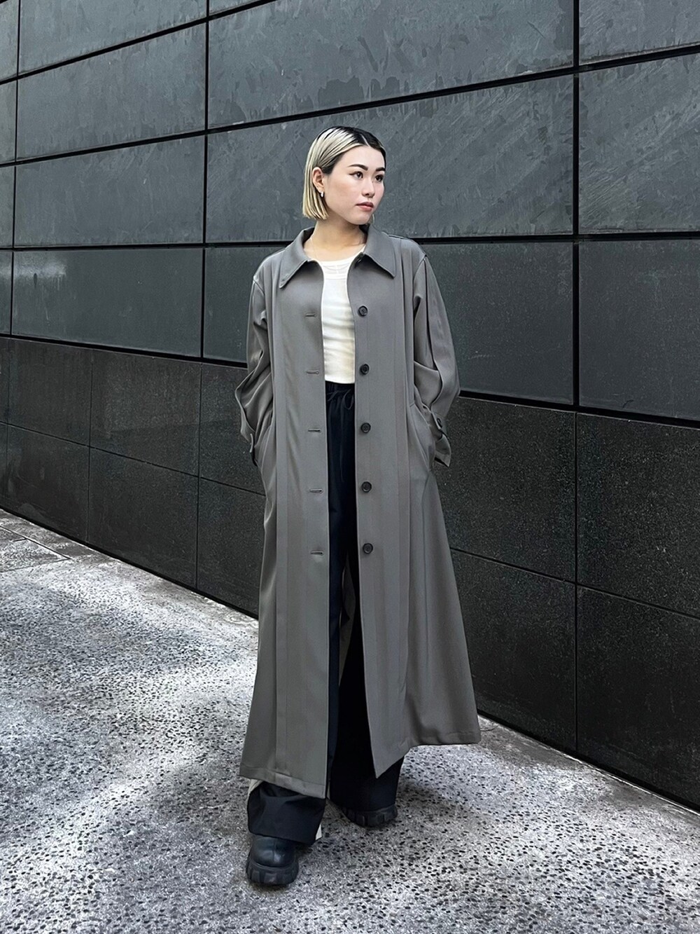 グレー系のトレンチコートを着用したレディースの秋コーディネートの4枚目の写真