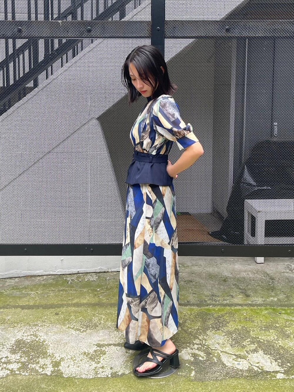 ブルー系のワンピースを着用したレディースの春コーディネートの2枚目の写真