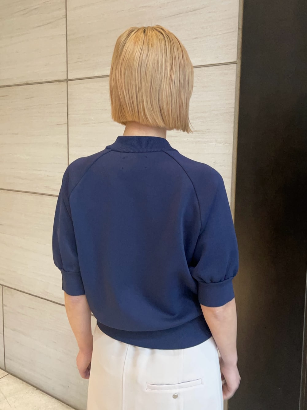 ブルー系のニット/セーター、ベージュ系のスカートを着用したレディースの春コーディネートの5枚目の写真