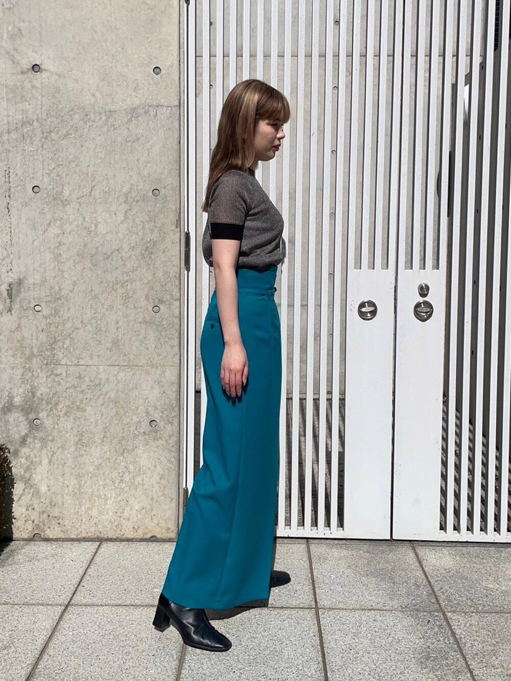 ゴールド系のニット/セーター、グリーン系のスラックスを着用したレディースの春コーディネートの4枚目の写真