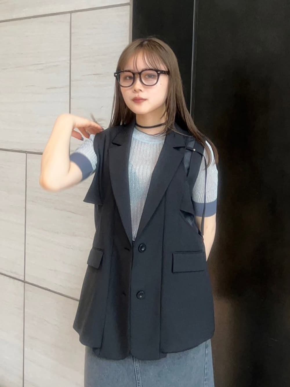 ブラック系のベストを着用したレディースの春コーディネートの5枚目の写真