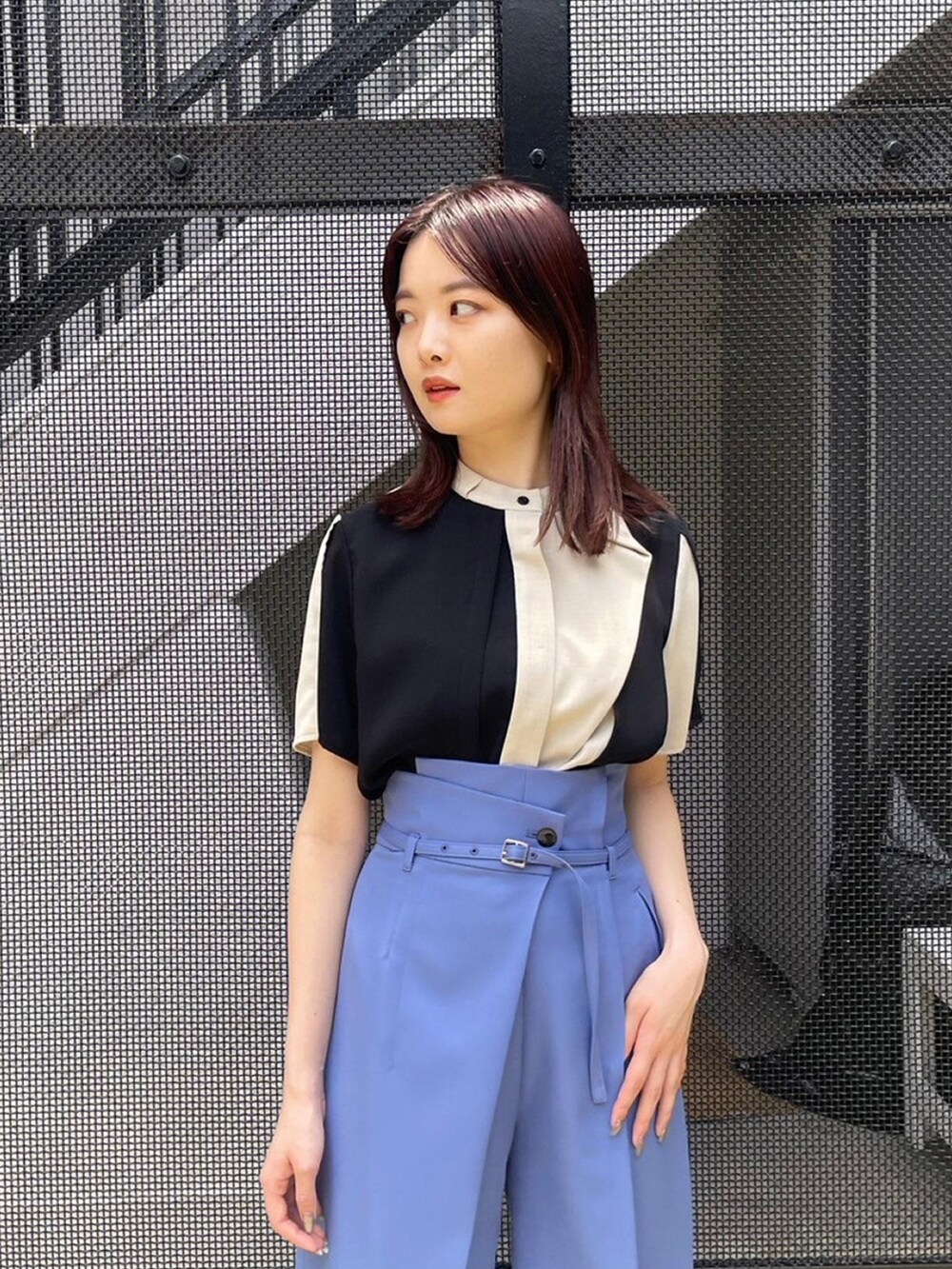 ベージュ系のシャツ/ブラウス、ブルー系のスラックスを着用したレディースの春コーディネートの5枚目の写真